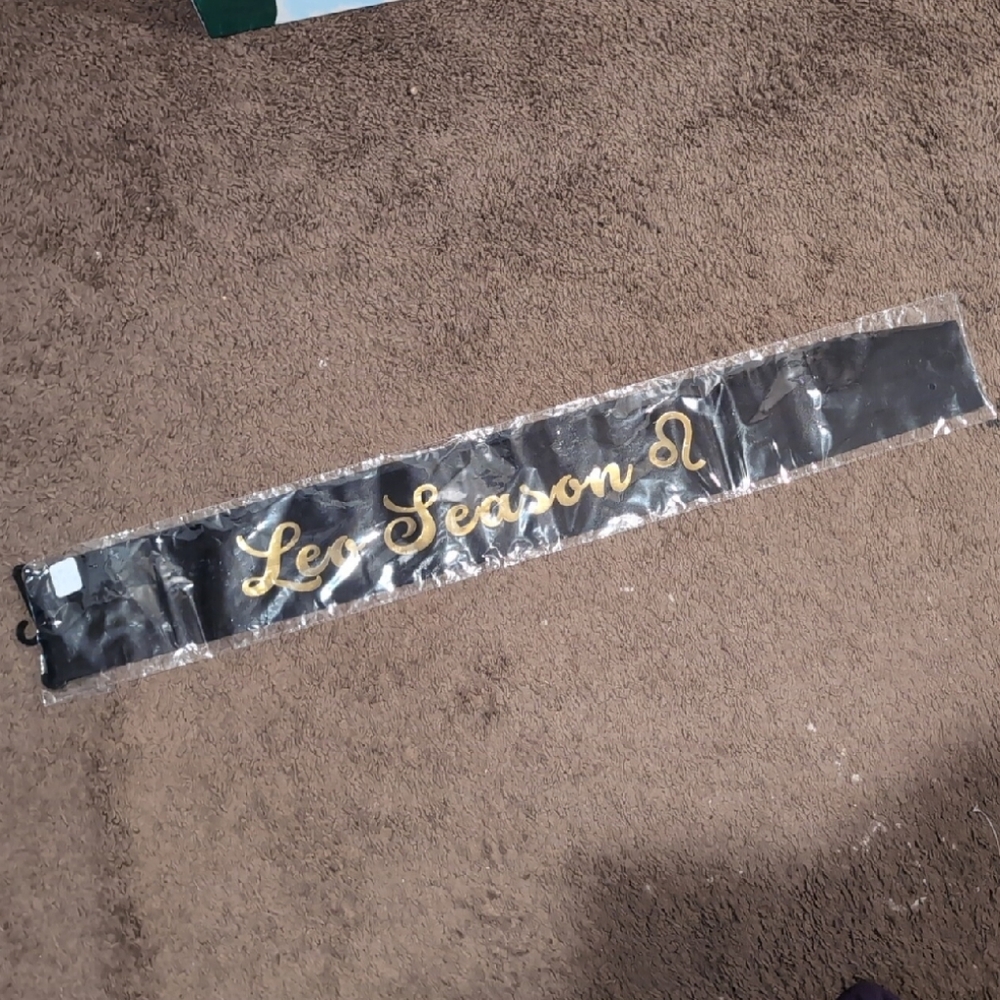 Black Sash with Gold 'Leo' Season' Text